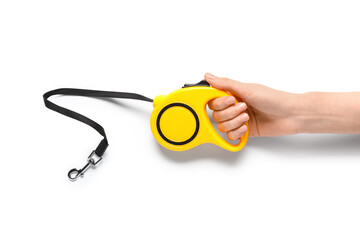 Naklejka premium Woman hand holding yellow retractable dog leash isolated on white background, closeup of automatic pet walking lead with clip and strap