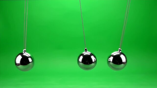 Three Polished Metal Spheres Swinging on Strings Against a Green Screen Chroma Key Background Demonstrating Pendulum Motion and Physics Concepts