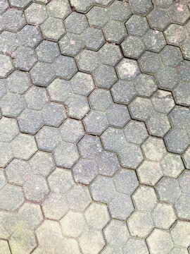 Top view of grey trihex paving blocks in a classic herringbone pattern