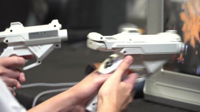 Player using light gun controller for split screen arcade style video game on CRT display