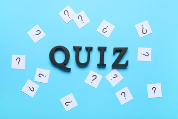 Fototapeta premium Word QUIZ with many question marks on blue background