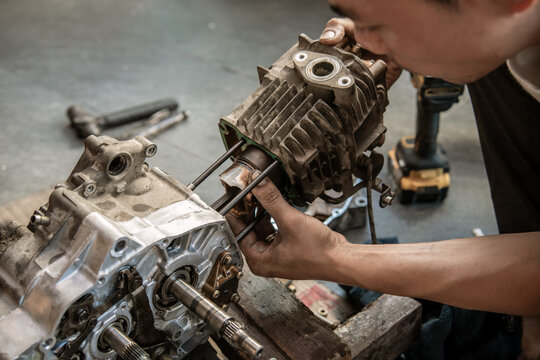 Mechanic Repairing Motorcycle Engine ,Motorcycle Engine Rebuild   Aligning Piston with Connecting Rod and Cylinder Studs selective focus on Piston