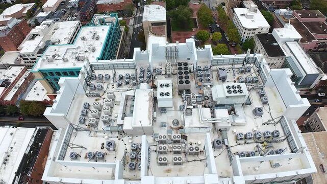 Aerial Rooftop Hvac Over Downtown Asheville Showing Dense Array Of Condenser Units, Fans, Ducts And Piping On White Commercial Roof Drone Overflight Captures Surrounding Brick Buildings,