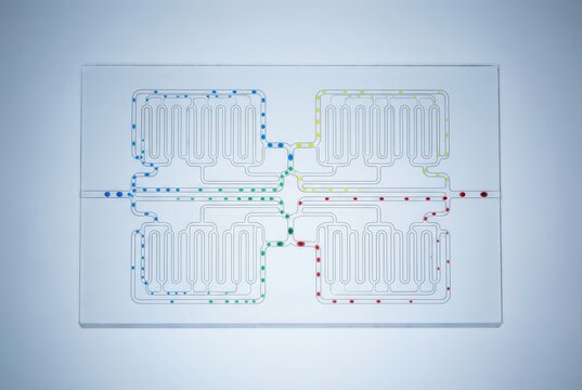 Innovative microfluidic device showcasing complex channel architecture with colored droplets representing dynamic fluid dynamics and integration of biotechnology concepts in cutting edge research