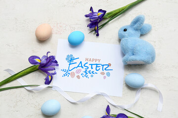 Greeting card with Easter eggs, toy bunny and beautiful flowers on white background