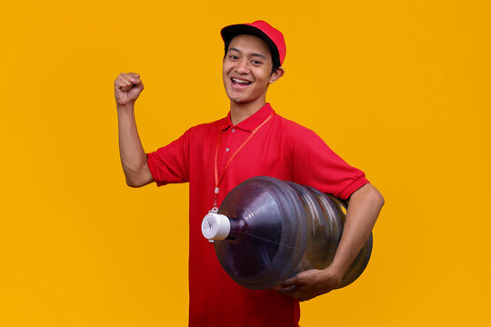Asian Courier in Red Cap and Polo Shirt Smiling Holding Heavy Water Bottle
