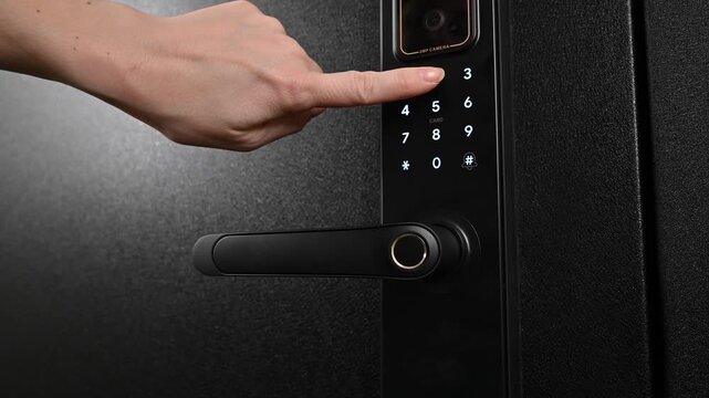 A woman opens a modern smart door lock with a digital keypad using a code.