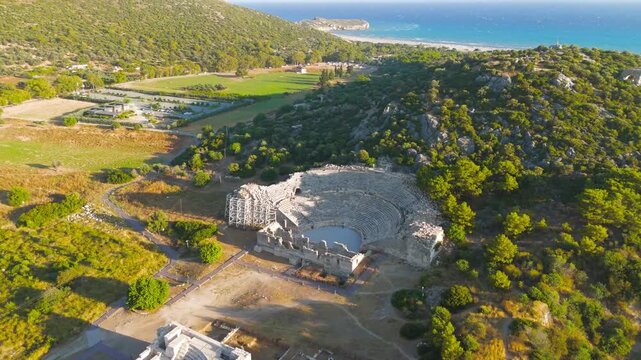 Gelemis, Turkey. Aerial view of Patara Ancient Theatre on slope of Kursunlu Hill, archaeological site with mediterranean landscape. Aerial View, MasterShots, Spiral forward