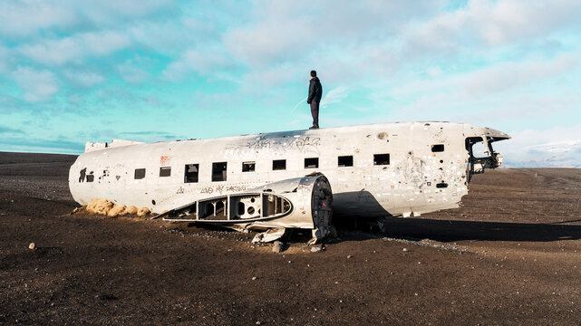 Man Standing on Abandoned DC-3 Plane Wreck, Iceland