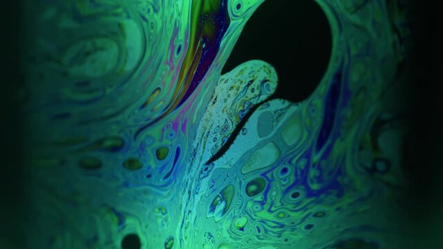 Blur emulsion spill. Circling fluid. Green neon blue color paint bubble dark black flow floating on abstract acrylic art background.