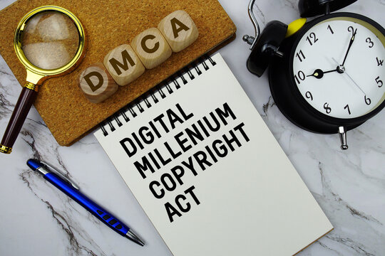 DMCA Digital Millennium Copyright Act text written on notepad with calculator and magnifying glass on marble background