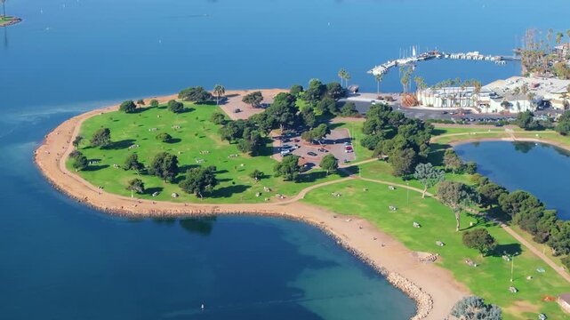 Coastal park and lagoon in Mission Bay San Diego during morning with calm blue water green landscape and soft sunlight creating bright peaceful scenic environment.