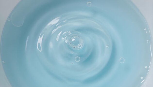Close-up abstract view of blue liquid with ripples and air bubbles forming concentric circles