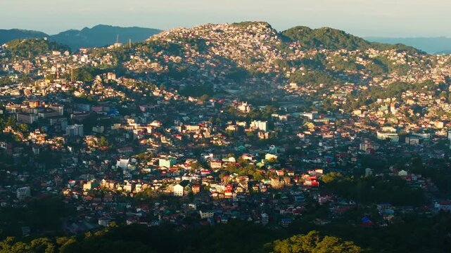 Morning light illuminating compact city across hills in Baguio Philippines