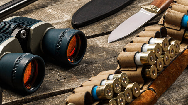 Items used for outdoor activities and hunting displayed on a wooden table