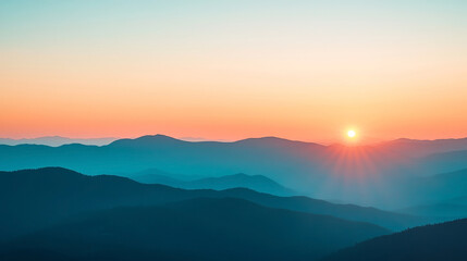 Obraz premium Breathtaking sunset over a mountain range, with vibrant orange and pink hues painting the sky as silhouetted peaks stretch to the horizon