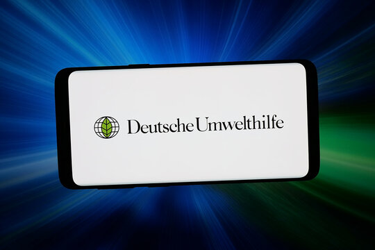 Stuttgart, Germany - 03-19-2026: In this photo illustration, the logo of association Deutsche Umwelthilfe e.V. (DUH) is displayed on a smartphone in front of abstract background on computer screen.