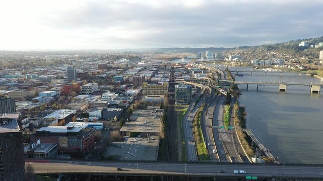 4K aerial drone view of I 5 and I 84 interchange in Portland Oregon USA toward south with Morrison Bridge, Hawthorne Bridge, Tilikum Crossing and Willamette River in sunrise light