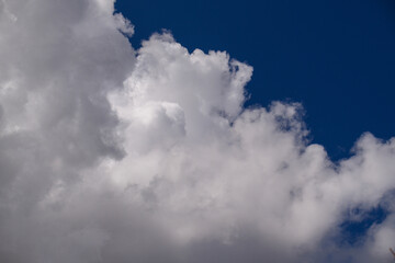 Obraz premium Dramatic sky with voluminous white clouds over rich blue backdrop