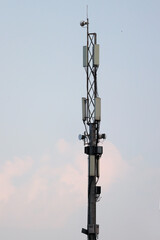 Fototapeta premium Mobile telecommunication tower with antennas against overcast sky