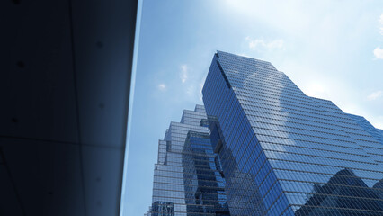 Naklejka premium Modern Skyscraper Featuring Glass Exterior Reflecting Blue Sky