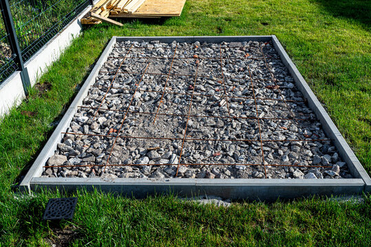 Foundation base for garden outbuilding construction in yard