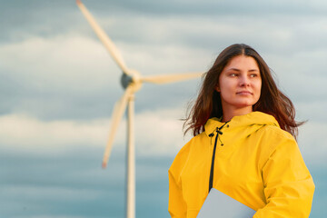 Woman engineer with tablet near wind turbine