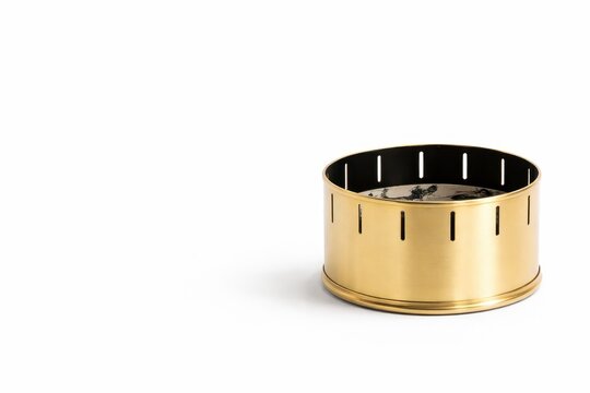 Polished brass zoetrope drum with precise cutout slits isolated on white background