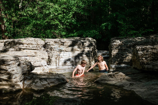 Children swimming in scenic Midwestern stream