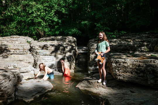 Preteen kids playing outdoors in rocky creek