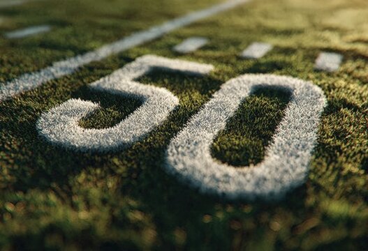 Close-up view of the number 50 painted on a football field, with green grass and white markings, showcasing the texture and detail of the turf and paint