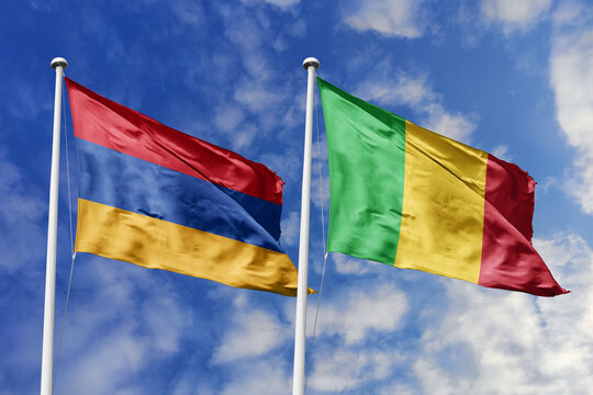 Armenia and Mali flags waving in a clear blue sky, symbolizing a powerful diplomacy, expanding global trade, a strategic partnership, and a shared vision of unity for a sustainable future.