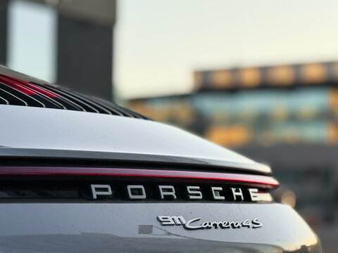 Silver Porsche 911 Carrera 4S VIII 992, sports car parked at the city street. Silver coupe sport car Porsche 911 Carrera 4S VIII 992 on parking lot. Exterior of a German sport car Porsche 911.