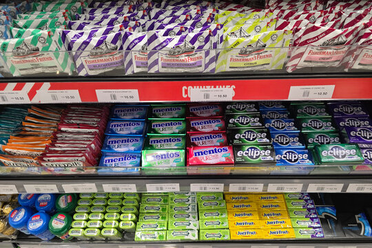 Bayan Lepas, Malaysia - Jan 21, 2026: Various brands of lozenges, mints, and chewing gum including Fisherman's Friend, Mentos, Eclipse, and Doublemint on retail shelves at a WHSmith store in Penang.