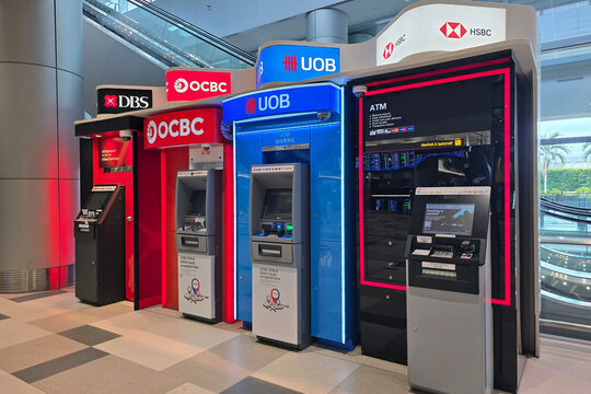 Changi, Singapore - Jan 21, 2026: A line of automated teller machines ATM including DBS, OCBC, UOB, and HSBC located in Terminal 2 of Singapore Changi Airport.