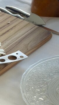Person in gloves slicing and arranging cheese on a plate