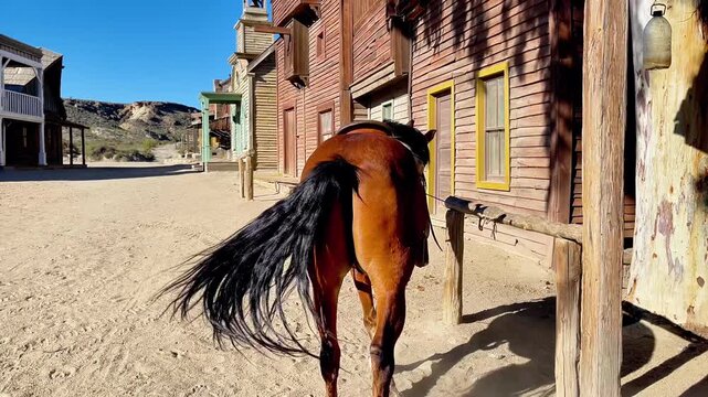 Lone Horse Tied to Hitching Post Outside Vintage Saloon in Desert Ghost Town