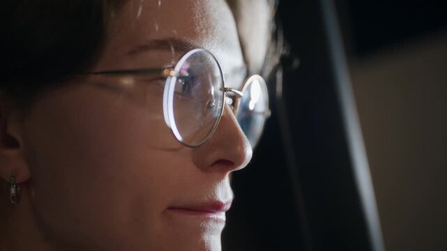 Extreme close up of female comedian wearing glasses fidgeting nervously with hands standing behind curtain while feeling heart racing before walking up on stage