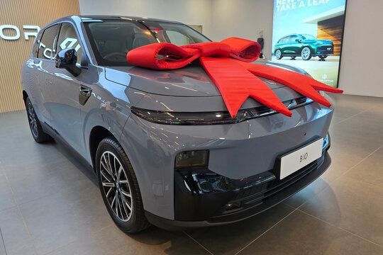 Penang, Malaysia - Feb 20, 2026: A front three-quarter view of a grey Leapmotor B10 electric SUV decorated with a large red ribbon bow on the hood.