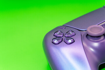 A gamepad for consoles on a green background, gaming addiction, gaming ban for teenagers, gaming controls for parents, for banners and advertising. High quality © Karen Vardanian