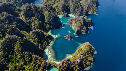 aerial perspective capturing the protected Kayangan Lake lagoon in Coron, Palawan. Stunning turquoise water surrounded by massive karst cliffs, traditional bangka boats © Michele
