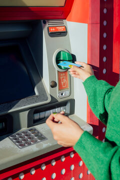 Hand inserting credit card at atm machine for cash withdrawal