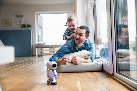 Father and son playing with robot at home having fun together