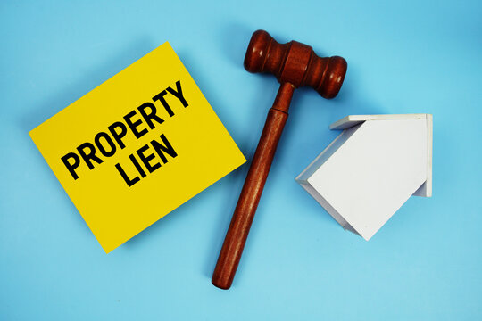 Property Lien text with judgment gavel and house model on blue background