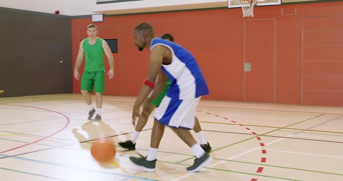 Faking right, man in blue shooting at hoop, green substitute leaping to rebound