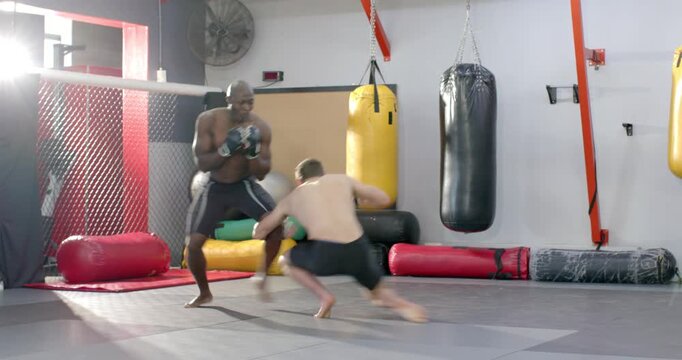 Diverse male fighters feinting punch, initiating takedown to secure mount in MMA cage
