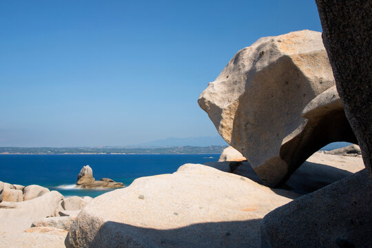 Travel, tourism: Granite rocks overlook the Mediterranean sea on a sunny day, creating a scenic landscape in Lavezzi islands, Corse du Sud, Corsica, France.