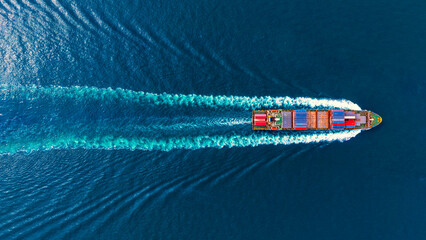 Aerial top view container ship full speed with beautiful wave pattern for logistics. © Teppakorn