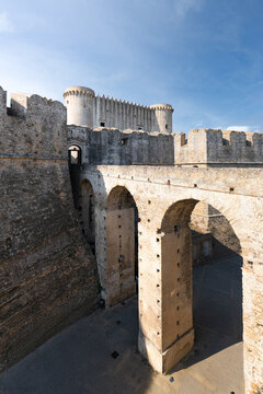 Aerial view of the Castle of Charles V featuring massive stone walls and an arched bridge in Crotone, Calabria, Italy.