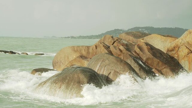 Splashing sea waves over big rocks